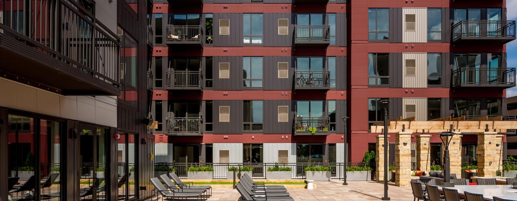 Courtyard featuring comfortable lounge areas with the Velo Warehouse District Minneapolis apartments in the background