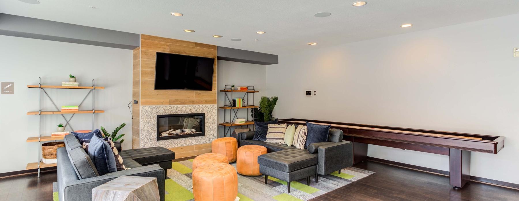 Modern resident lounge with couches, TV, and fireplace at Velo, an urban apartment complex in Minneapolis