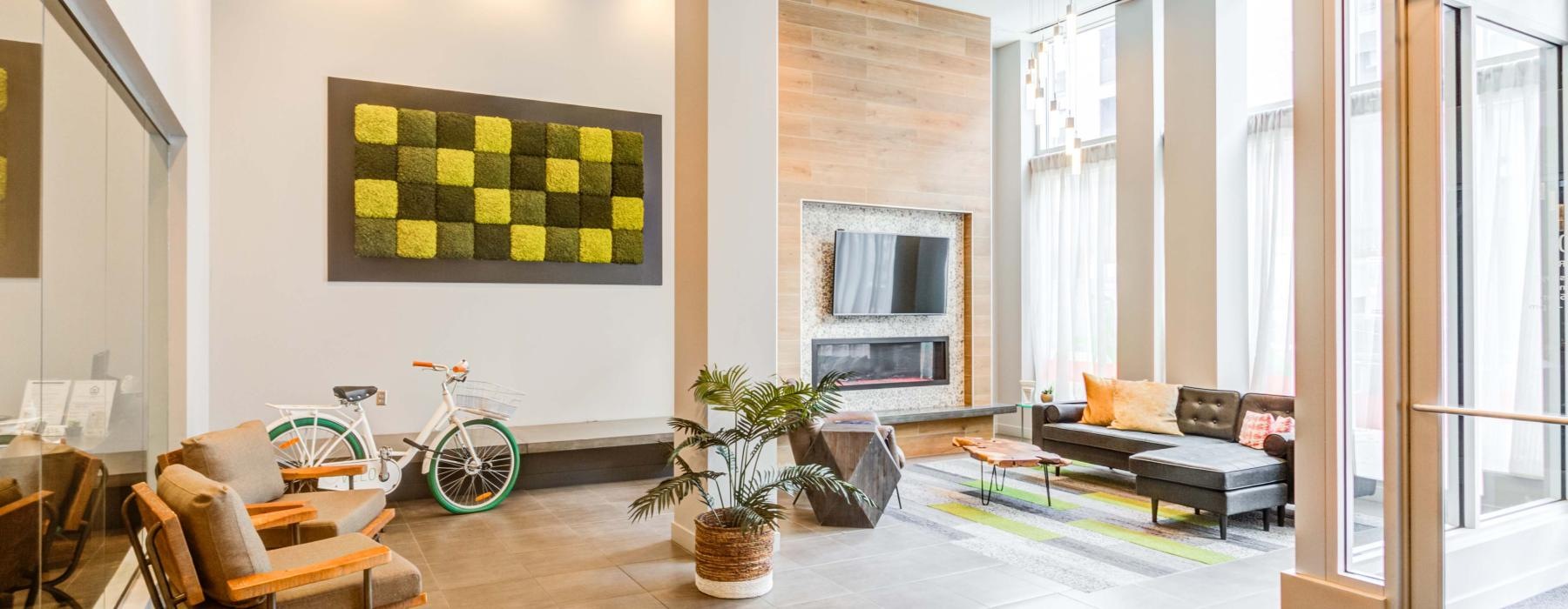 Lounge with modern furniture, TV, fireplace, and floor-to-ceiling windows at Velo, the best apartments in Minneapolis